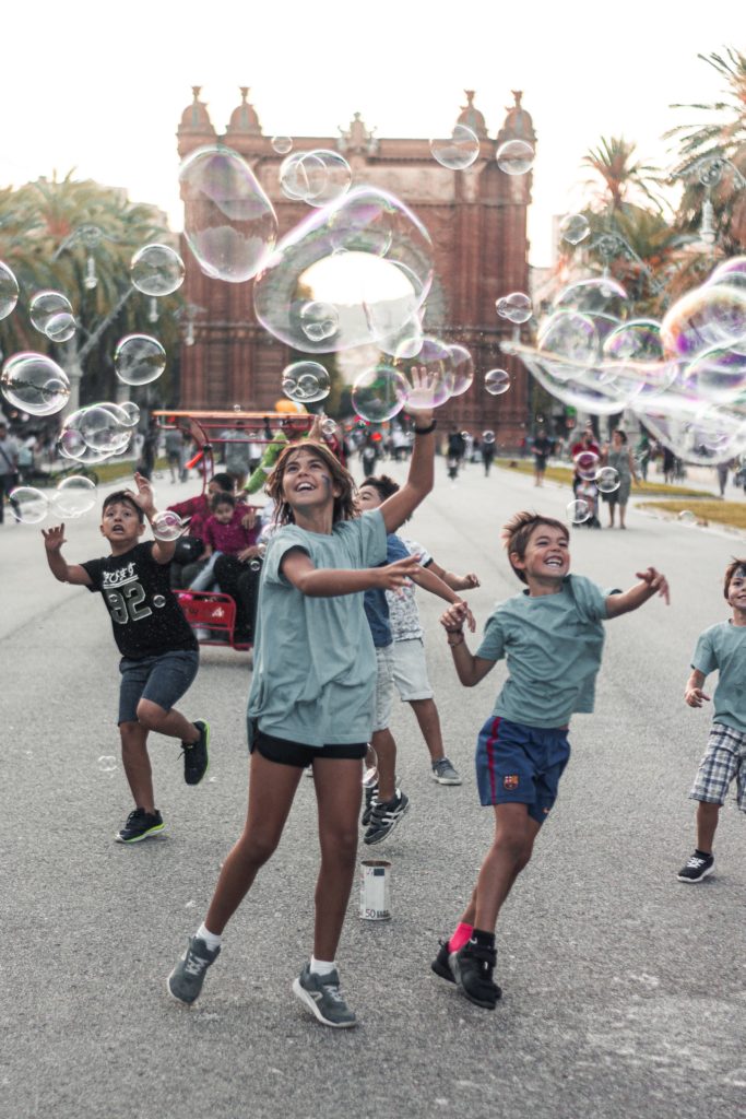 kinderen spelen op straat met zeepbellen